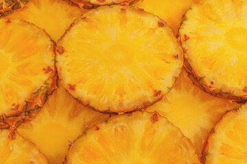 Pineapple juicy yellow slices as a background.
