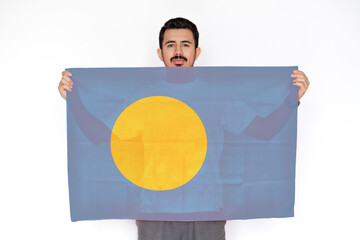 Young man holding Palau flag, protest or social issues in Palau, independence day idea, two hands 