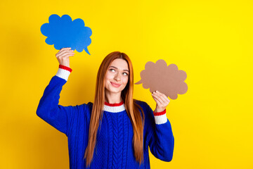 Photo portrait of attractive young woman hold look comics clouds dressed stylish blue knitwear clothes isolated on yellow color background