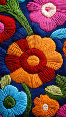 Naklejka premium Vibrant embroidered flowers on a rich blue background, showcasing intricate stitching and bright colors, perfect for textile design.