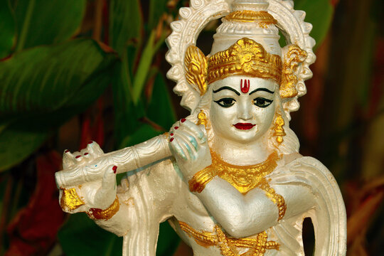 Religious statuette of Krishna with flute. Portrait photo.