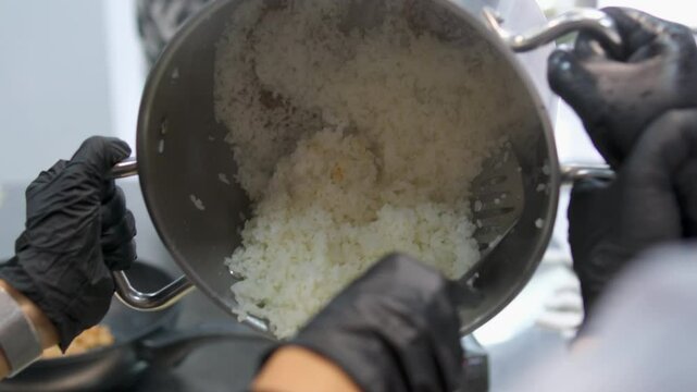 cool boiled rice. White Millet is highly nutritious cereal healthy fresh organic in salad dish.Hand of chef drawing Hot Boiled millet seed to dish for cool down and serve with milk.