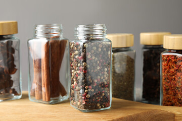 Different spices in glass jars on table