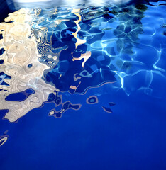 Captivating reflections on serene water surface captured during a bright day by the poolside with gentle ripples and textures
