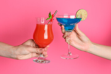 Friends with glasses of refreshing cocktails on pink background, closeup