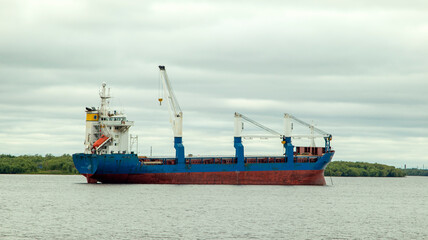 A large cargo sea vessel is at anchor, a dry cargo ship is at anchor