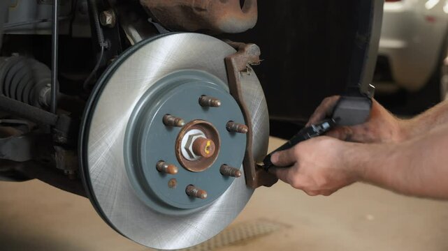 Close up footage of Auto mechanic installing new brake discs on a vehicle