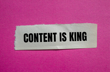 Content is king message written on ripped torn paper piece with pink background. Conceptual content is king symbol. Copy space.