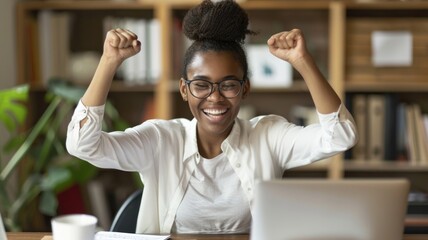 Obraz premium Excited woman celebrating success at her desk.