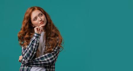 Portrait of curious analyzing woman in blue studio.Mindful girl finding solution