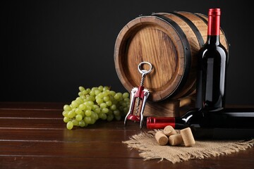 Wing corkscrew, corks, bottles of wine, grapes and barrel on wooden table
