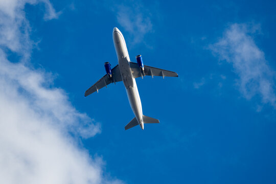 Airplane flying overhead in blue sky