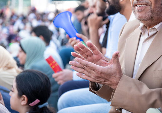 A proud father clapping joyfully enjoy a joyful graduation ceremony, celebrating family, love, success, and winning competition