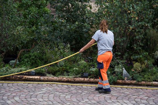 Mulhouse - France - 4 september 2024 - portrait on back view of gardener watering  in a public garden - Powered by Adobe