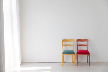 Fototapeta premium Two old vintage chairs in the interior of a white room near the wall