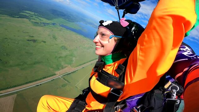 Close-up of a happy young woman enjoying a skydiving with the instructor