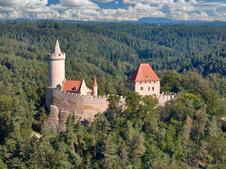 Stunning Aerial View of Kokorin Castle – A Medieval Gem with Red Roofs and Tower Amidst the Czech green Forest, Perfect for Historical and Travel Content.
