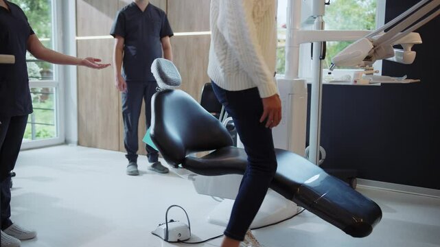 Woman patient comes and sits in the dental chair. Assistants and man dentist start the procedure. Hydience and healthy
