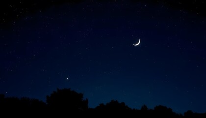 A crescent moon in a dark blue night sky, with silhouetted pine trees in the foreground