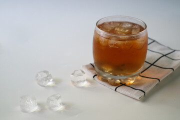 Ice tea with ice cubes on the side, isolated on white background. Iced tea is a refreshing beverage made by brewing tea and then cooling it, typically served over ice.