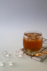 Ice tea with ice cubes on the side, isolated on white background. Iced tea is a refreshing beverage made by brewing tea and then cooling it, typically served over ice.