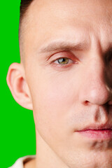 Fototapeta premium Close-Up Portrait Of A Man With Green Eyes Against A Bright Green Background