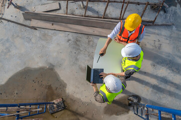 Two Asian engineer working at site of a large building project,Thailand people,Work overtime at construction site,Team of engineer discus at site