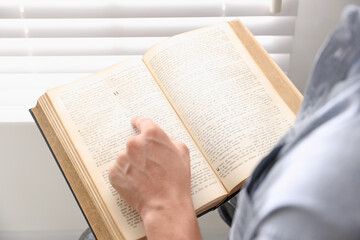 Fototapeta premium Man with Bible indoors, closeup. Christian faith