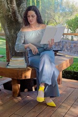 Woman Reading Books Outdoors on a Wooden Bench