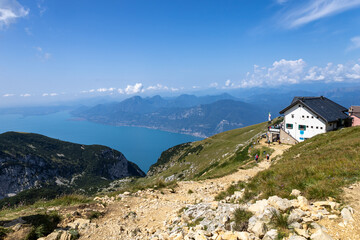 path on the Monte Baldo massif with Barana refuge and Lake Garda in the background on the border between the Veneto region and Trentino Alto Adige, Italy
