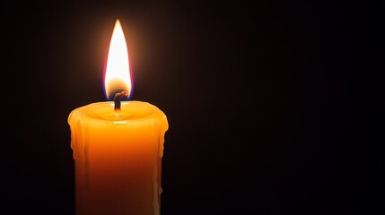 A close-up of a lit candle with a warm glow against a dark background, creating a soothing atmosphere.
