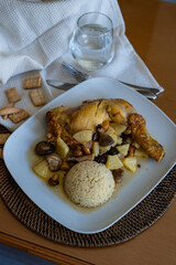 roast chicken with pineapple and mushrooms served with couscous at a home's table