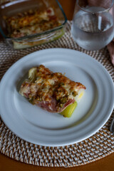 leek au gratin with cheese in the oven at a table at home