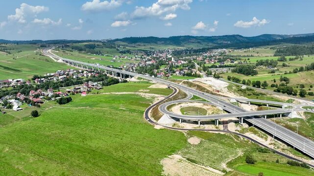 Last fragment of Zakopianka highway, Poland, between Rdzawka nad Nowy Targ with junction with traffic circle, ramps and high viaduct over Klikuszowa village, just opened in September 2024. Aerial view
