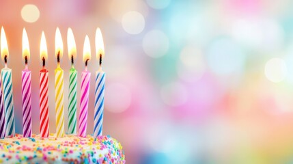 Colorful birthday candles glowing brightly on a decorated cake with festive background during a celebration
