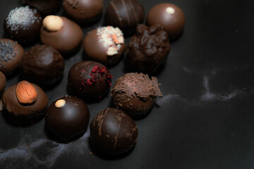 Assorted chocolate bonbons on a black marble