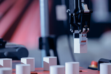 Small AI robotic arm moves heavy parts along conveyor belt, concept of automated assembly line in...