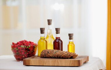 Extra virgin set oil of sunflower, olive in glass bottles, vinaigrette salad and multigrain bread on background of kitchen, eco nature super food