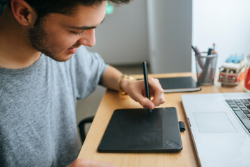 Close up of young boy using graphic tablet