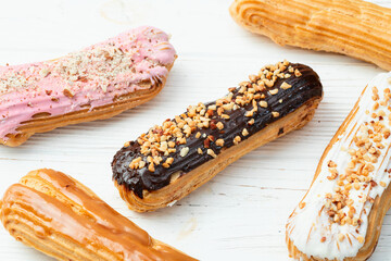 Assorted eclairs on a pastel top view Traditional French dessert