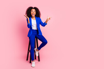 Photo of cheerful glad nice lovely girl wear trendy blue clothes sit wooden chair empty space isolated on pink color background
