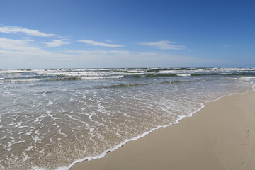 Wellen brechen am Strand von Sandhammaren in Schweden an einem sonnigen und stürmischen Sommertag
