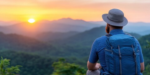 An adventure traveler who hikes appreciates taking a pause to look at the summit of the mountain at dusk.