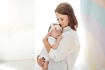 mom puts the baby to sleep by rocking him, mom holds the baby in her arms gently hugging and...