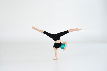 rhythmic gymnast performing with ball, showing skills and stay isolated on white background....