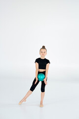 Fototapeta premium rhythmic gymnast performing with ball, showing skills and stay isolated on white background. Concept of sport, active lifestyle, hobby.