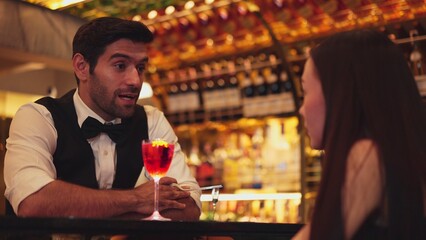 Bartender serving mixed vodka Cosmopolitan red cocktail decorated with flower for beautiful guest at luxurious counter bar perfect vibrant color presentation highlight atmosphere nightclub. Vinosity.
