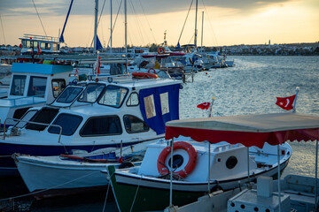 Fishing boats and yachts moored in the marina at sunset. Boats in the harbor at sunset. Fishing...