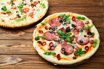 2 pizza with mozzarella cheese , salami sausages , olives , chicken , pineapple and tomatoes