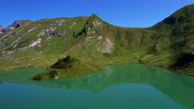 4K Aerial Drone video of the most beautiful mountain lake Schrecksee in Bavarian Alps with the cows feeding on lush green grass on a sunny day with blue skies and rocky hill tops surrounding